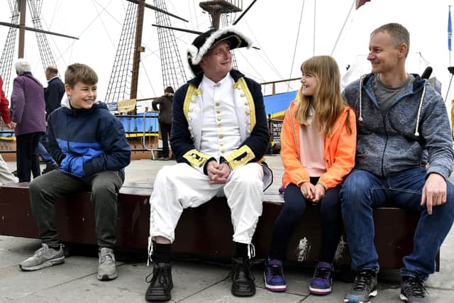 Visitors to Whitby's Fish and Ships Festival meet Captain Cook on a bench.
