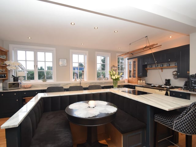 The kitchen's central island has a breakfast bar and an inner dining arrangement.