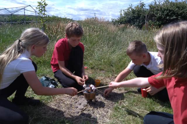 Oakridge School pupils toasting marshmallows.