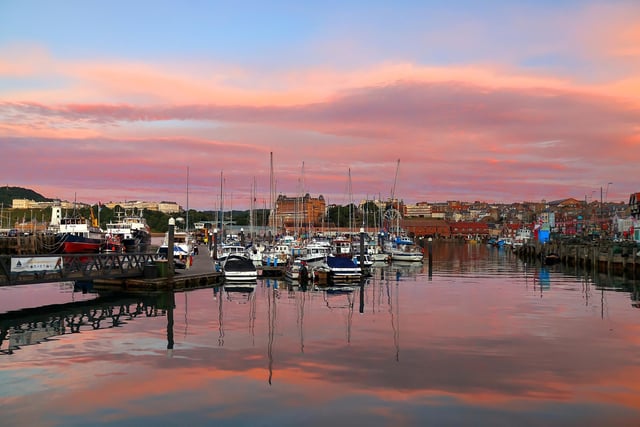 Tranquil harbour with rainbow skies.