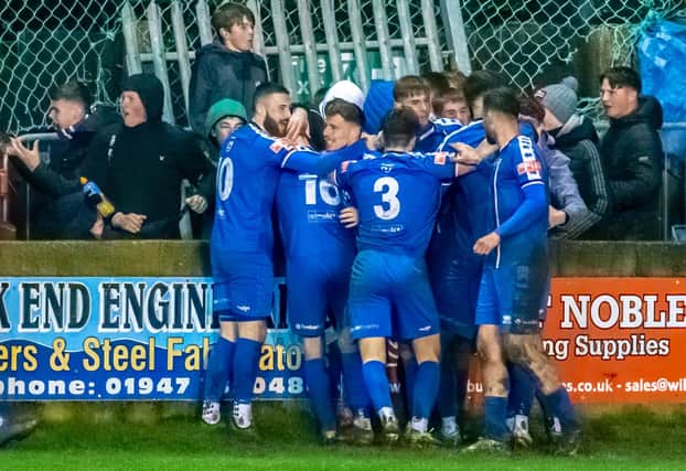 The Whitby Town players celebrate with Dan Rowe after his late equaliser against high-flyers Hyde PHOTO BY BRIAN MURFIELD