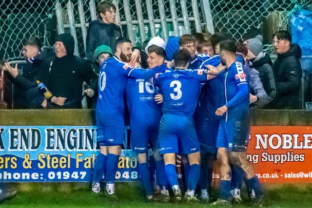 The Whitby Town players celebrate with Dan Rowe after his late equaliser against high-flyers Hyde PHOTO BY BRIAN MURFIELD