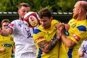 Kev Burgess of Marske United heads the ball away from Lewis Hawkins