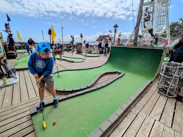 Trying for a hole in one at Pirate Adventure Mini Golf.