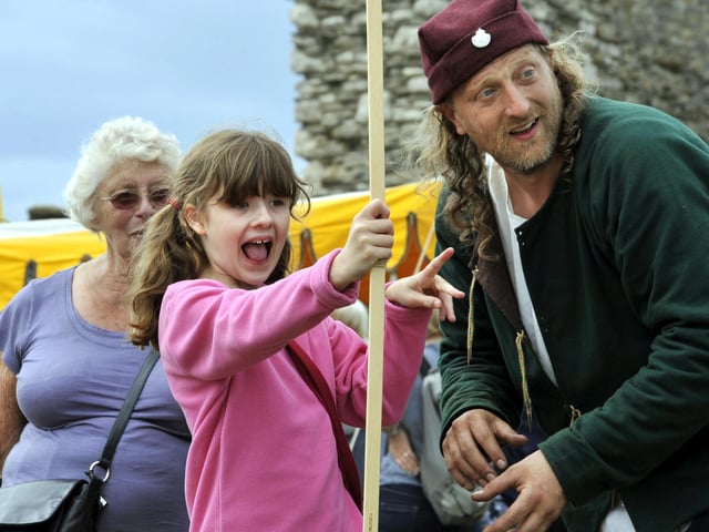Jean Skilbeck looks on as her grand-daughter Natasha Woodham tries her archery skills, with Martin Hudgkins, one of the medieval group at the castle. picture by Andrew Higgins