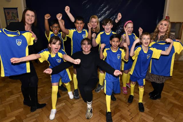 Mel Benson of Castle Employment, Head Cheryl Cappleman, sports coordinater Hannah Bishop, Emma Horton of Castle Employment and pupils show off the new multi-use kit