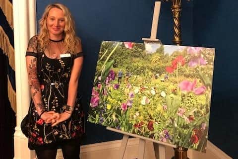Christine Wilson with her photo of the garden which won 3rd place out of 90 entries.