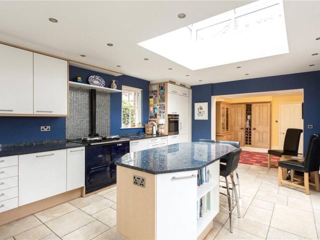 A recently updated kitchen has modern units with a central island.