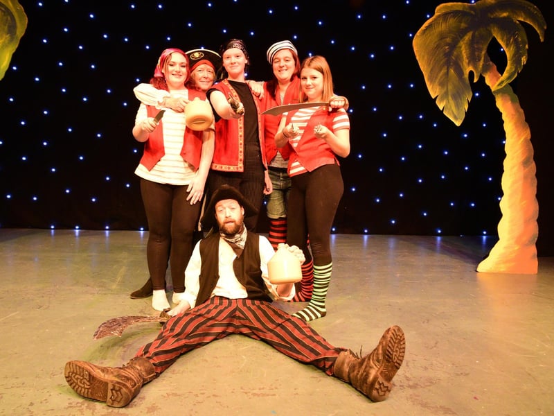 Long John Silver (Ivan Hall) with his band of pirates.