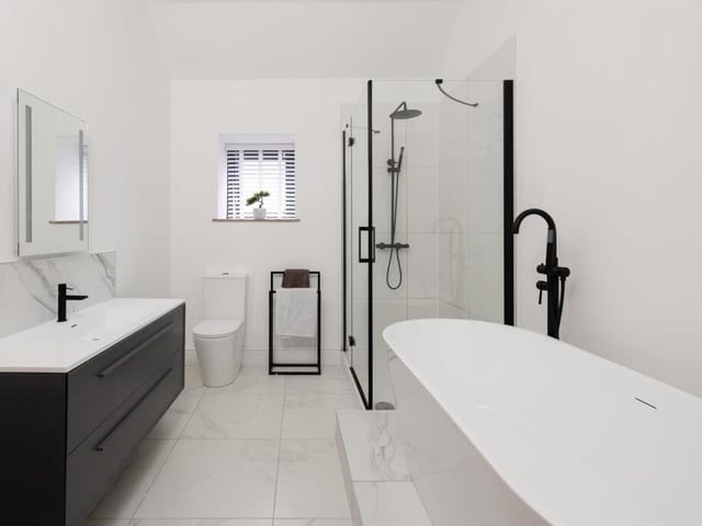 A contemporary style bathroom with free standing bath and walk-in shower.