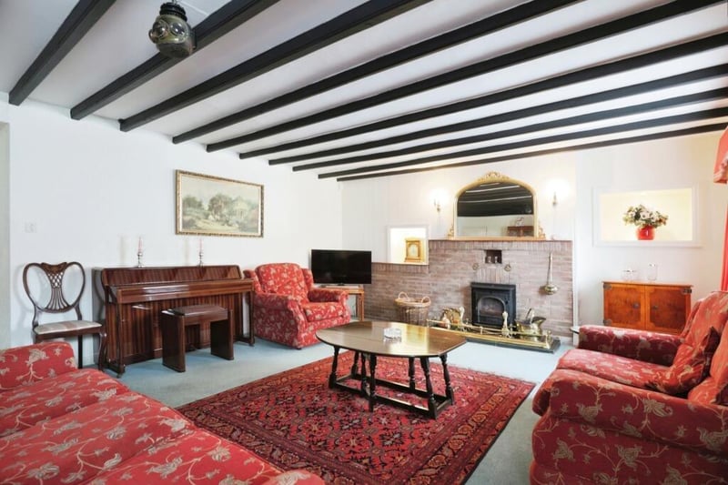A beamed reception room with feature fireplace.