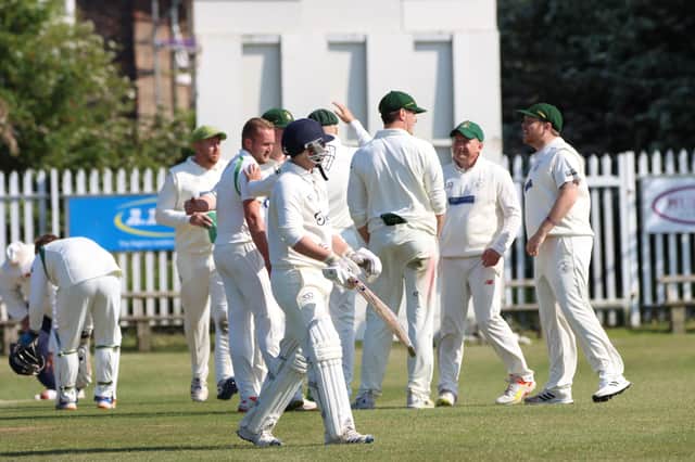 A Sutton-on-Hull batter trudges off as the Bridlington CC players celebrate claiming their wicket in the 67-run home win. PHOTO BY TCF PHOTOGRAPHY