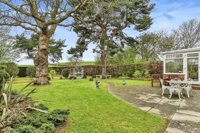 The lovely lawned garden with patio area has an open outlook.