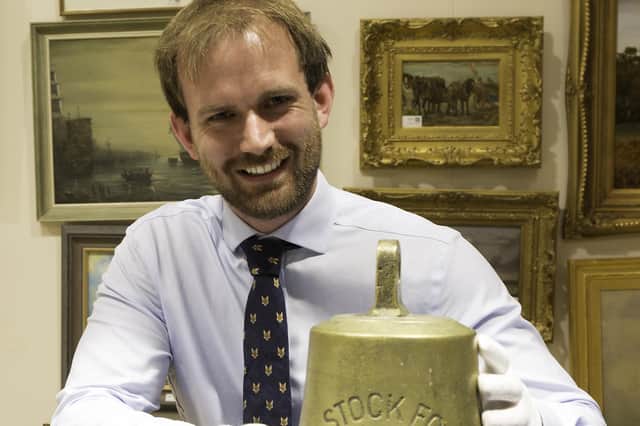 Auctioneer Tom Fouracre Reid with the bell of the SS Stock Force.
