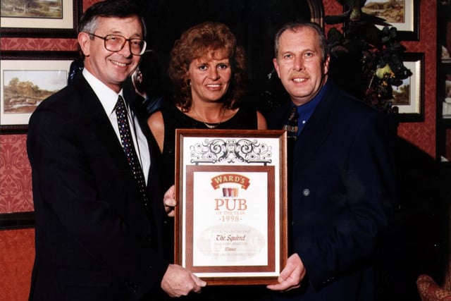Licensees Bob and Pauline Woolley receiving their Pub of the Year award from Barry Arnold, left, regional director, Ward's Brewery.