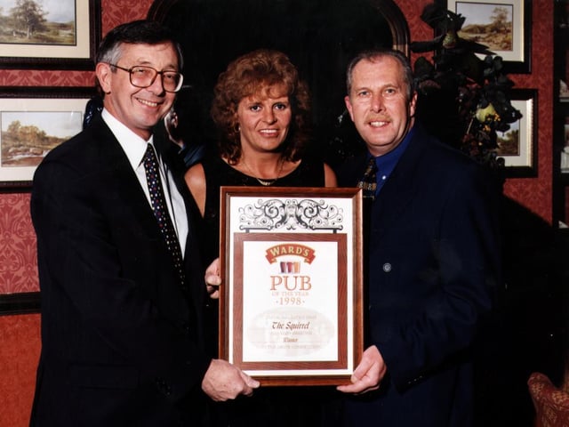 Licensees Bob and Pauline Woolley receiving their Pub of the Year award from Barry Arnold, left, regional director, Ward's Brewery.