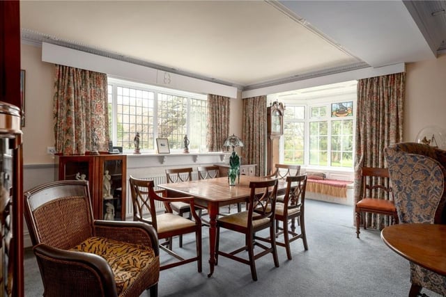 A bright dining space, with a bay window and window seat with views of the gardens.