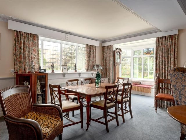 A bright dining space, with a bay window and window seat with views of the gardens.