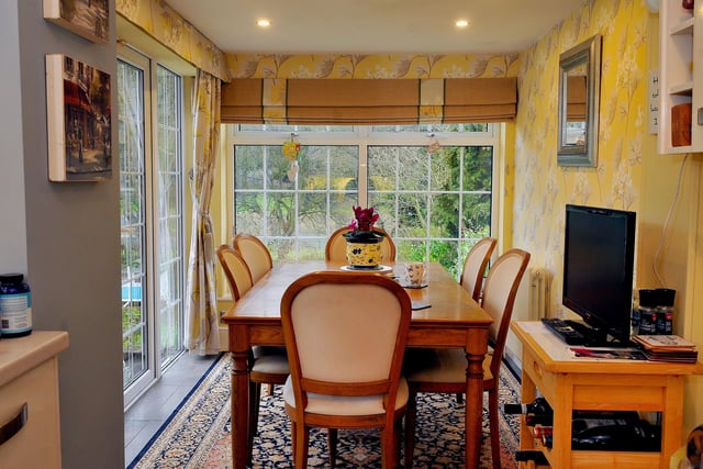 A conservatory or sun room, currently used as a dining space.