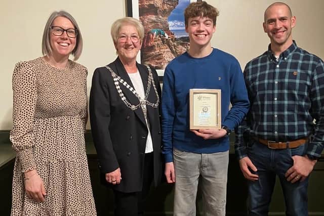 Whitby Mayor Sandra Turner presents Isaac Harrison with his award, with Isaac's parents Lucy and Matthew.