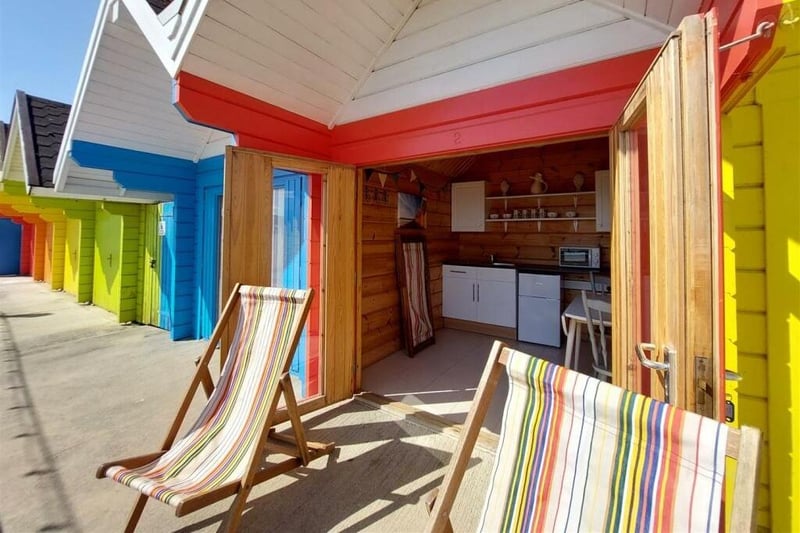 Inside a single-storey beach chalet, with deckchairs, a kettle and a sink provided.