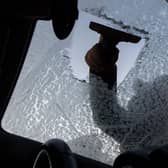 Person scraping windscreen.