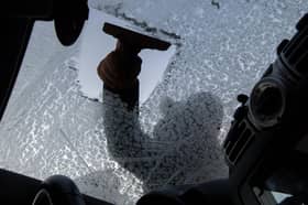 Person scraping windscreen.
