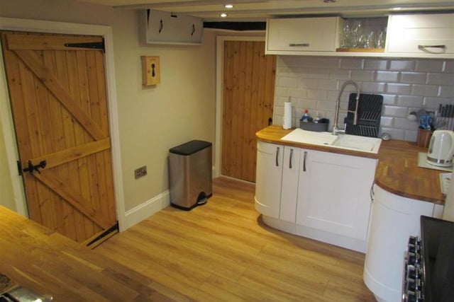 The country style kitchen has fitted units and wood block worktops.