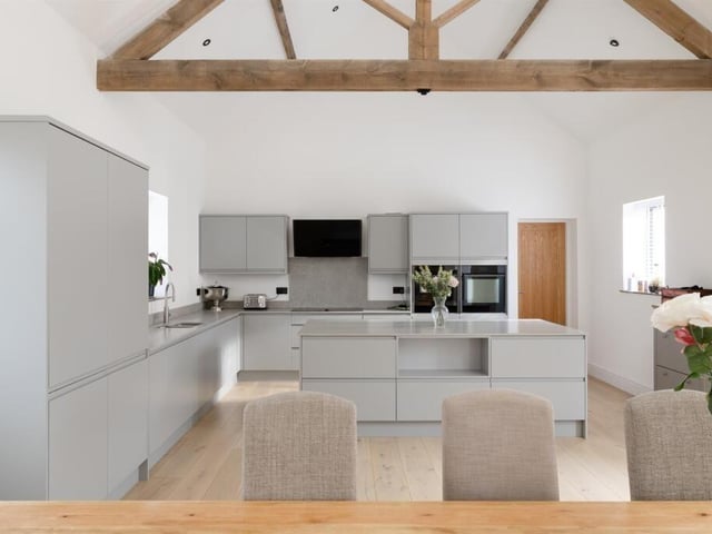 The high spec fitted kitchen has a central island and granite worktops.