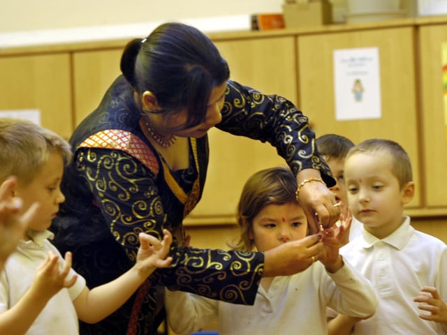 Bangladeshi dance teacher Rushia Uzmi visits Gladstone Road infants school. Shwoing a girl how to hold her fingers.
Picture by Dave Barry, 074646d