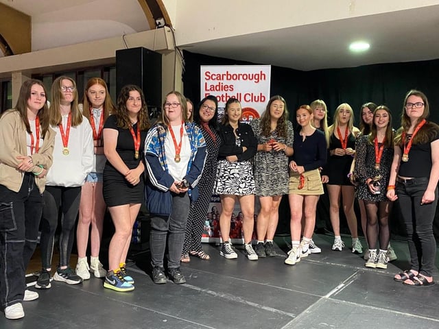 The Scarborough Ladies FC Under-15s collect their medals and trophies.