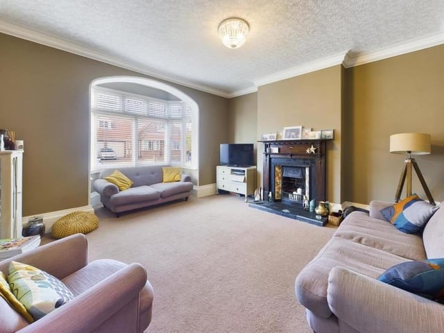 The lounge has a large bay window and a feature fireplace.