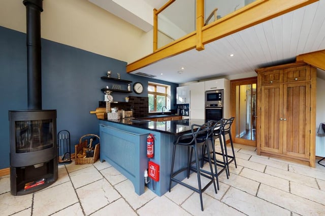 A modern kitchen with fitted units, granite worktops and a breakfast bar.