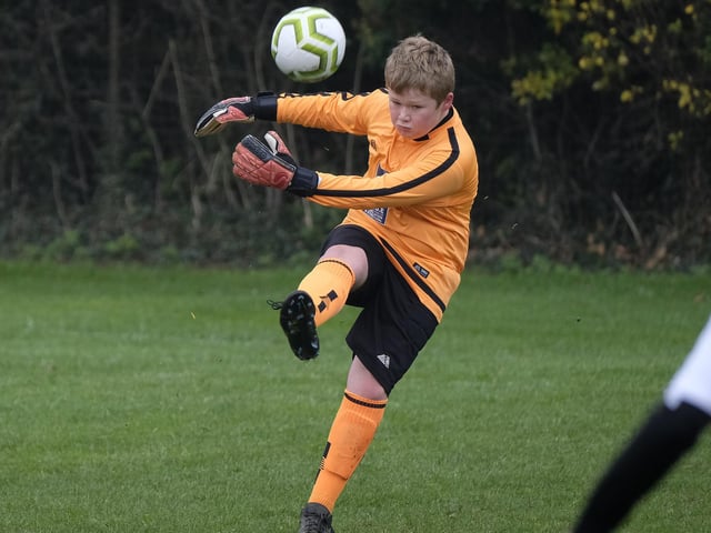 The visiting goalkeeper kicks the ball clear