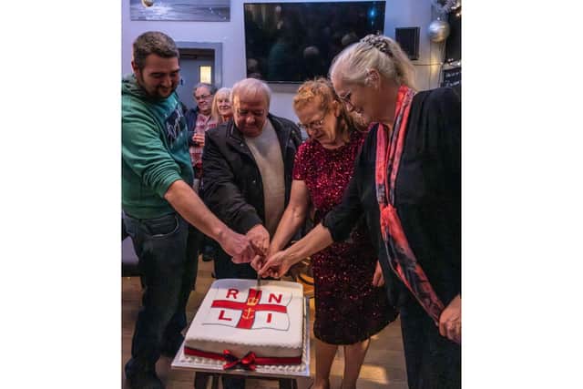 Celebrating volunteers cutting the cake during the Christmas crew gathering - Image: RNLI/James Stoker