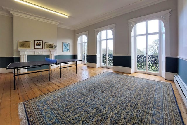 A decorative wrought iron balcony remains outside this attractive room with French doors and feature fireplace.