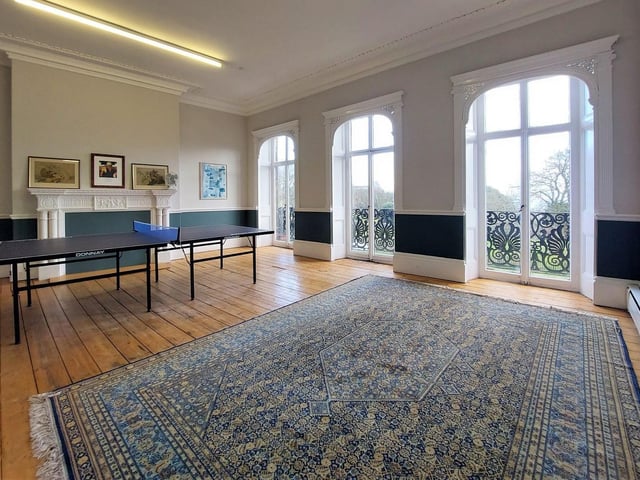 A decorative wrought iron balcony remains outside this attractive room with French doors and feature fireplace.