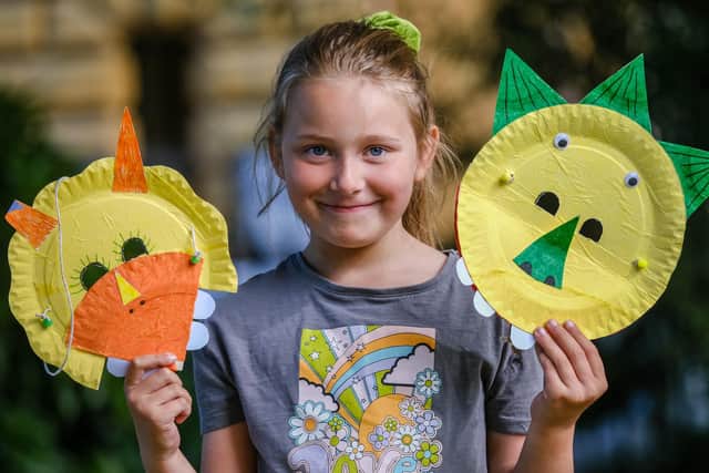 Seven-year-old Daisy Lewis with a dinosaur mask