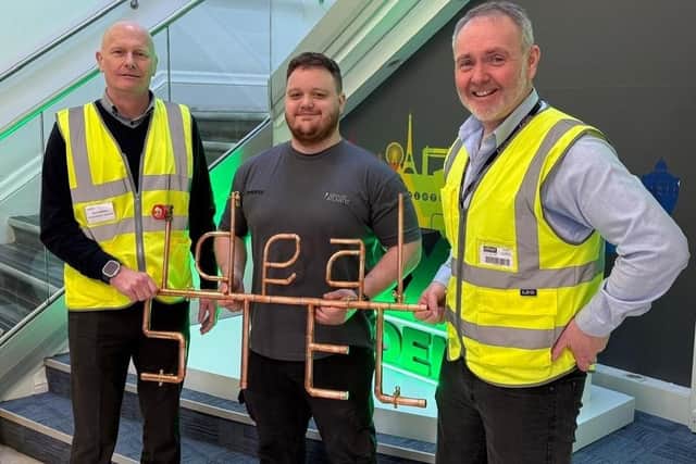 From left, Ideal Heating Finance Director – Operations Aaron Spence, Apprentice Technician Lewis Speedy and Production Director John Cook, with the handmade copper pipe artwork gifted by Scarborough TEC students.