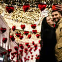 A couple poses for a selfie under heart-shaped balloons displayed for Valentine's Day in downtown Moscow on February 13, 2020. (Photo by Dimitar DILKOFF / AFP) (Photo by DIMITAR DILKOFF/AFP via Getty Images)