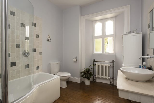 A stylish bathroom with bath, shower and vanity unit.