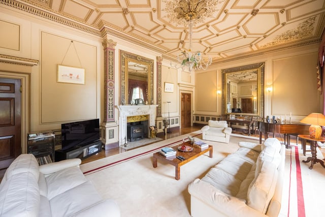 A spacious sitting room with a stunning central fireplace.