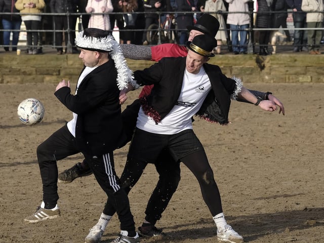 Top-hatted players battle for the ball