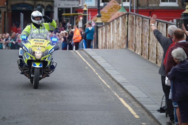 A wave for the police officer on his motorcycle.