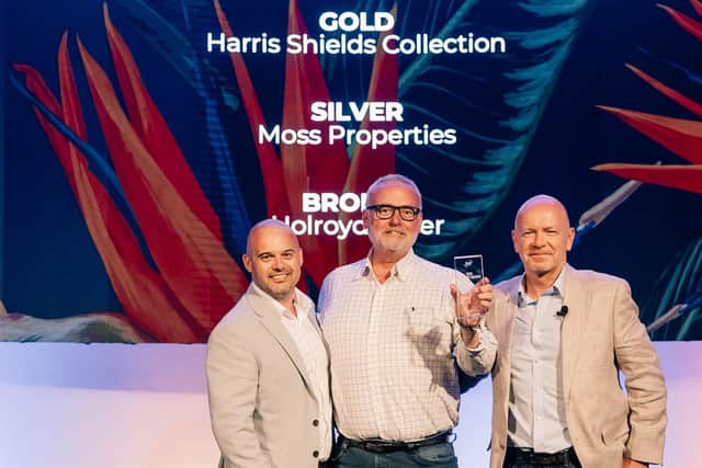 Mark Shields, director of Harris Shields Collection, (centre) receives the award.