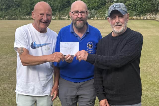 Nigel Trotter, left, and Harry Old, right, won the North Cliff Doubles Merit and receive their winner's cheque from Cliff president Greg Long, who sponsored the event.