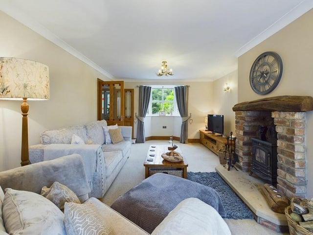 The lounge has a feature brick fireplace with log burner, and doors to the patio and garden.