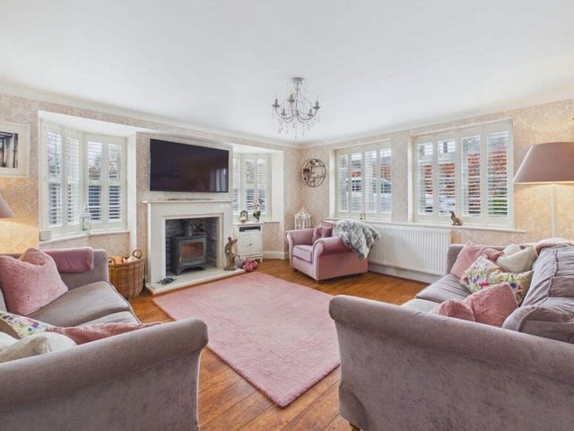 A lovely, dual aspect living room has a cosy wood burning stove.