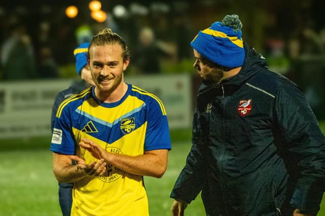Noah Wadsworth, pictured with coach Jimmy Beadle, applauds the travelling fans at Macclesfield. Photo by Chris Marson