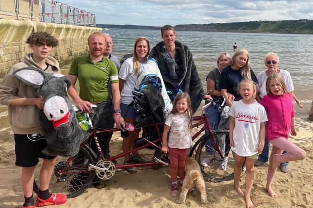 The two fundraisers enjoying their victory on Scarborough beach with friends and family.